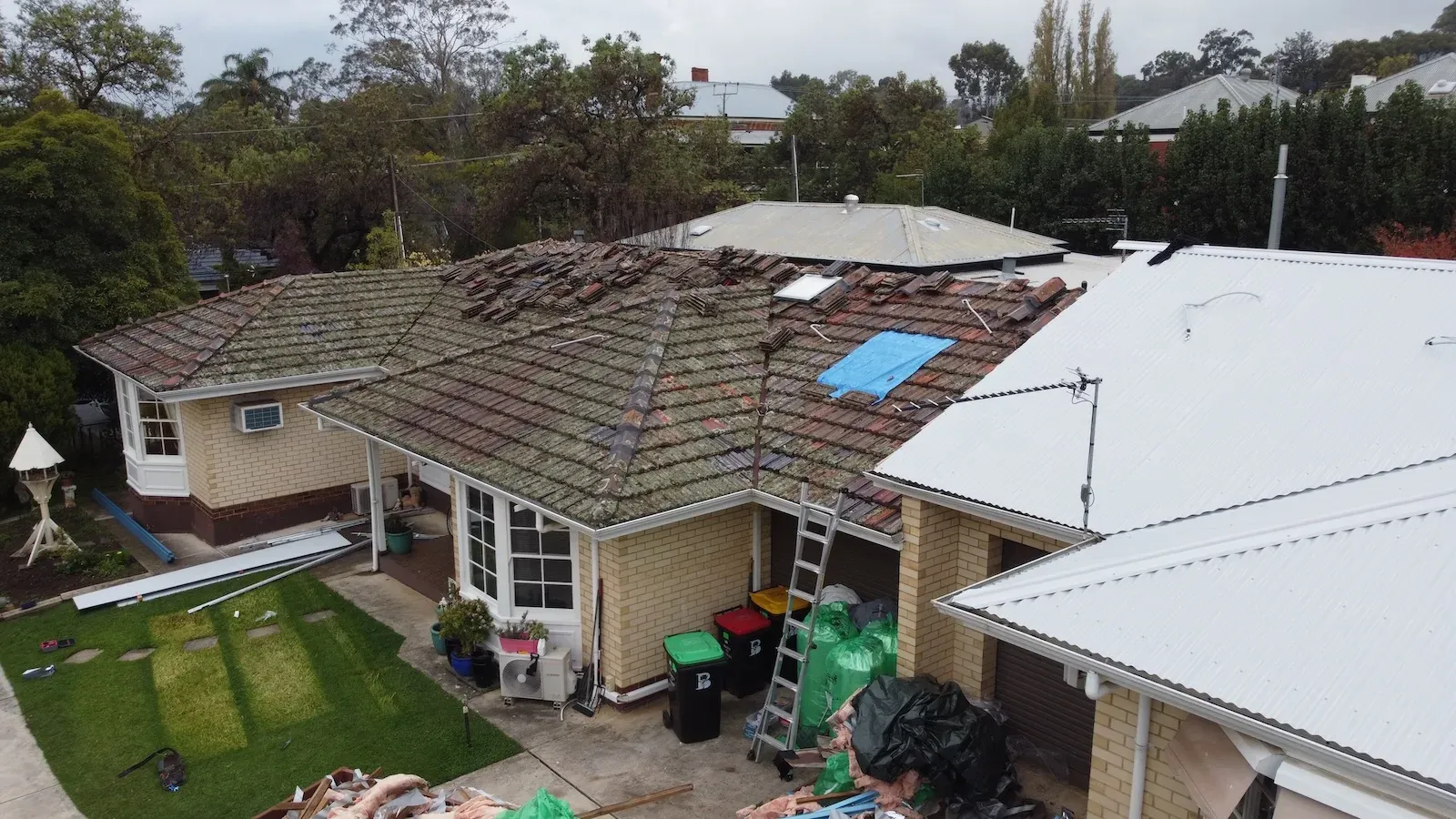Adelaide home part way through a roof replacement, worn tiles beside a finished Colorbond roof
